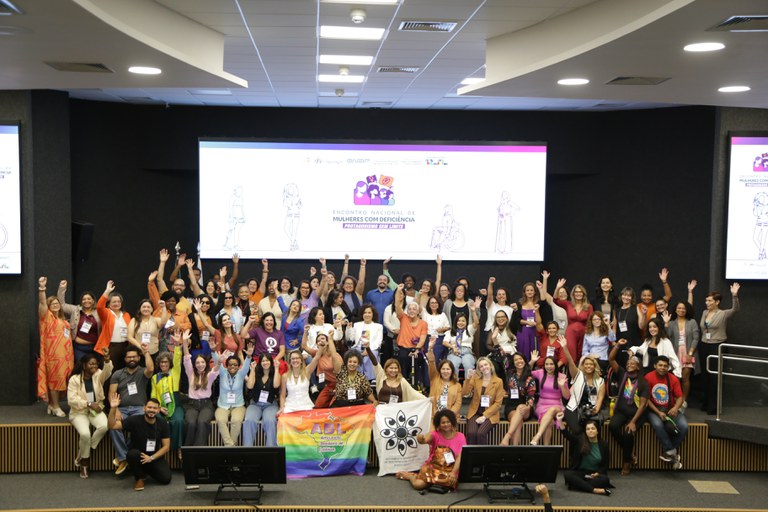 Grupo diverso de mulheres com deficiência reunidas em evento, celebrando inclusão e protagonismo.