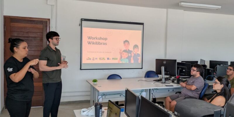 Workshop sobre Wikilibras com intérprete de Libras e participantes em sala de informática.