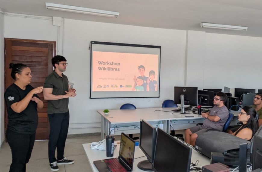 Workshop sobre Wikilibras com intérprete de Libras e participantes em sala de informática.