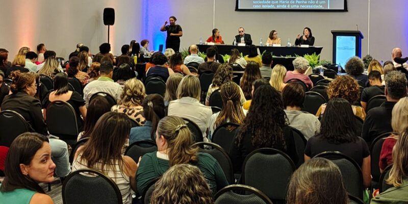 Auditório cheio com pessoas assistindo a um painel de debates sobre educação especial.