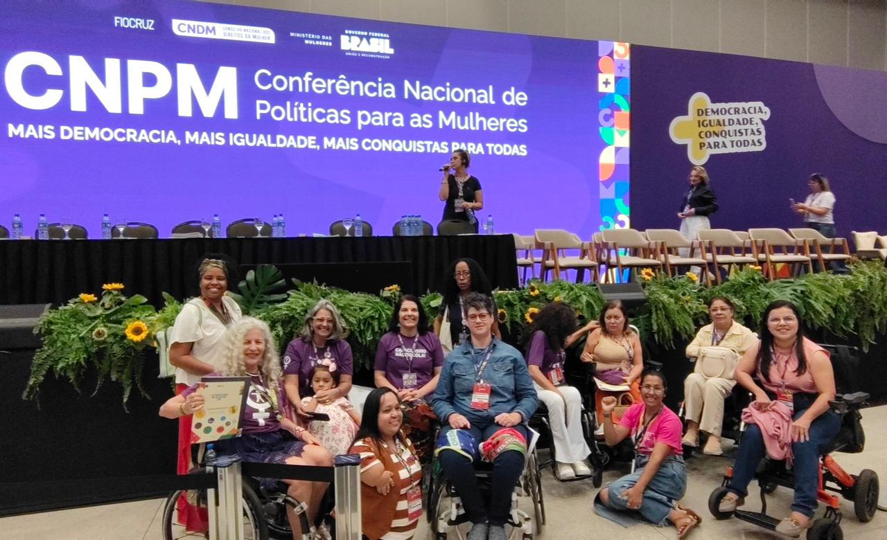 Grupo de mulheres com deficiência reunidas no palco da 5ª Conferência Nacional das Mulheres.