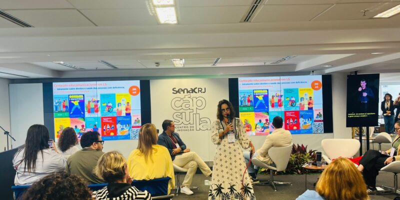 Pessoas assistem palestra inclusiva com intérprete de Libras e conteúdos sobre saúde e direitos.